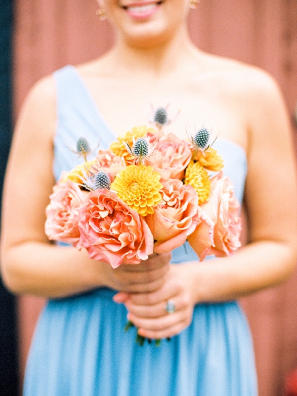 Pale blue bridesmaid with peach and orange bouquet