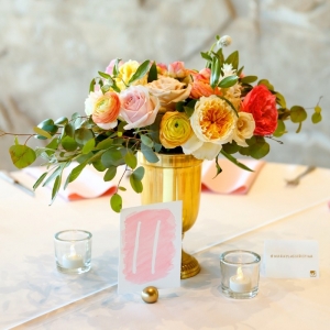 Yellow, orange, and pink centerpiece with a watercolor table number