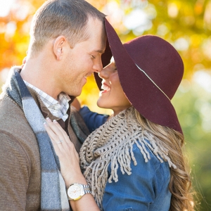 Engaged Couple with a Floppy Hat & Fall Colors Behind