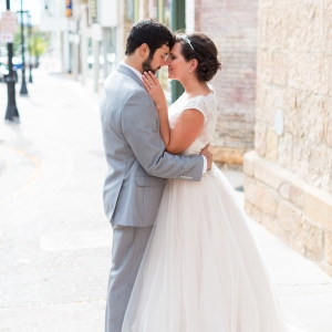 Groom In Gray And Bride In A Sleeveless Lace And Tulle Gown