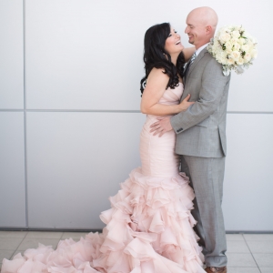 Bride in blush gown and groom in gray suit 