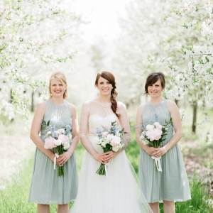 Bride and bridesmaids in cherry tree orchard 