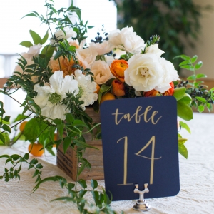 Elegant orange, white, and navy centerpiece and table number