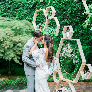Couple in front of hanging honeycomb backdrop