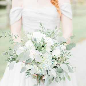 Bride in gray wedding dress with greenery bouquet