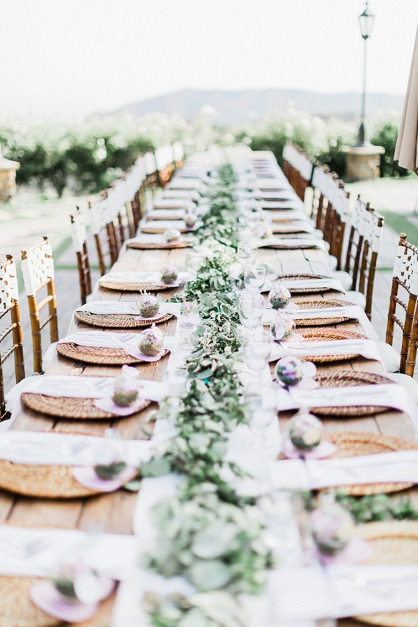 Long table wedding reception with terrarium place settings