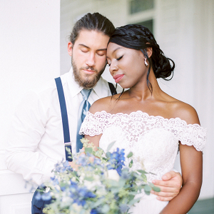 Bride in off white lace dress with blue bouquet