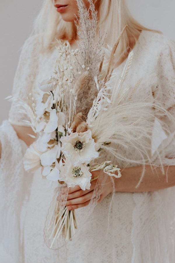 bride holding a white orchid bouquet