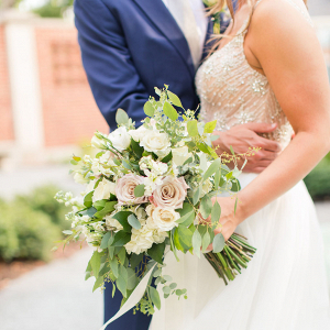 bride holding a white and blush rose bouquet