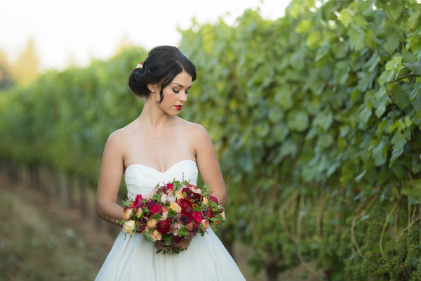 Beautiful bride in a simple white gown in a vineyard
