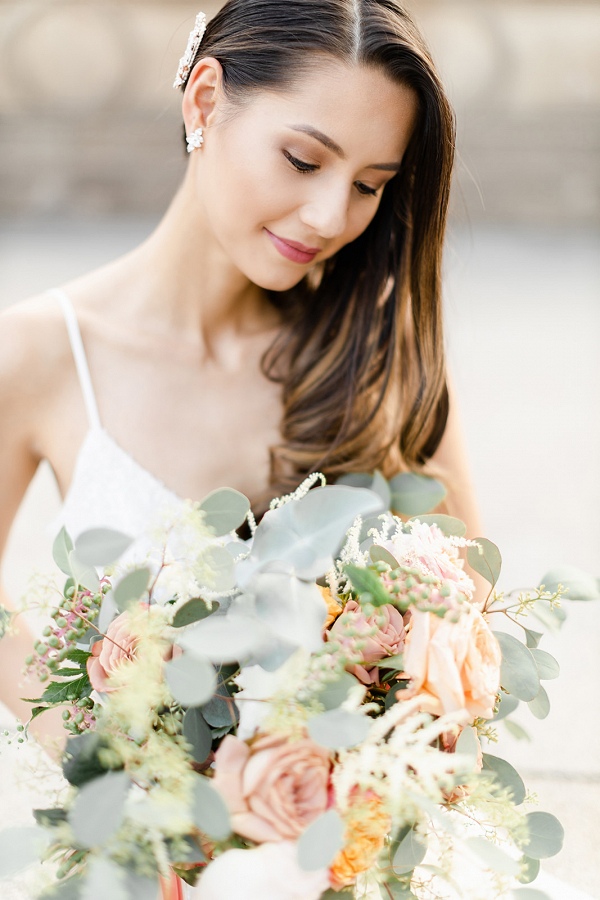 Bride looking down and holding a rose bouquet