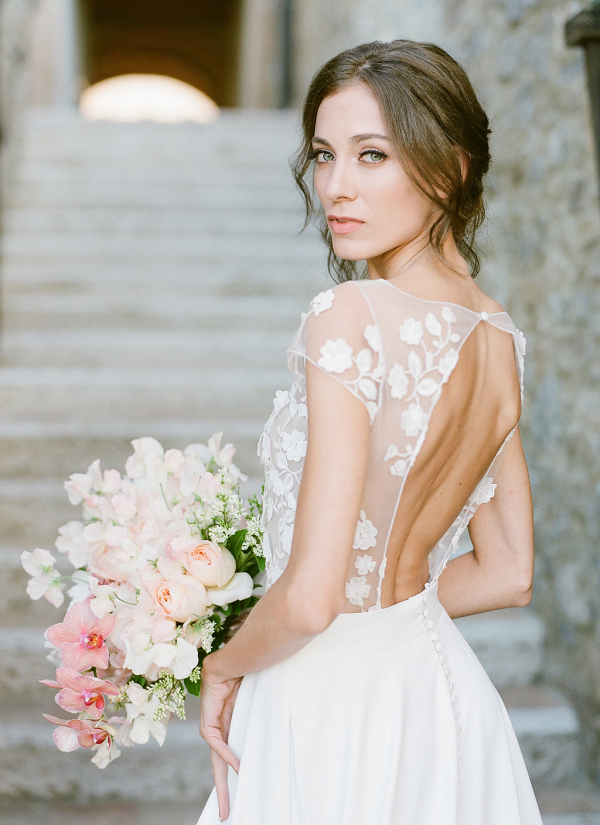 Bride with open back, floral applique gown and light pink bouquet