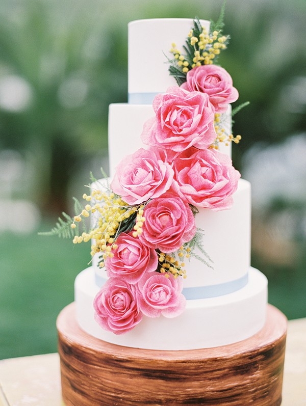A Clean White Wedding Cake with Pink and Yellow Flowers