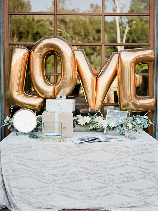 Metallic Gold LOVE Balloons for a Wedding Welcome Table