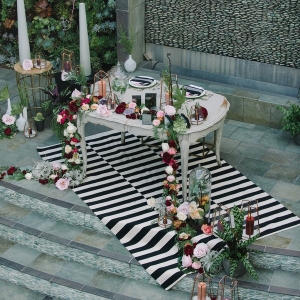 Sweetheart Table with Black and White Stripes and a Floral Runner with Geometric Lanterns