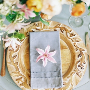 Place Setting with a Carved Wooden Charger and Spring Flowers