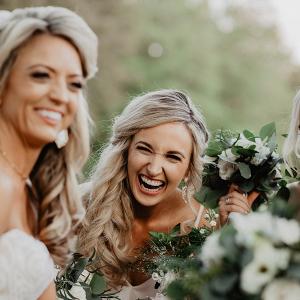 Bridesmaid laughing with bride