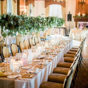 Wedding reception with tall greenery centerpieces