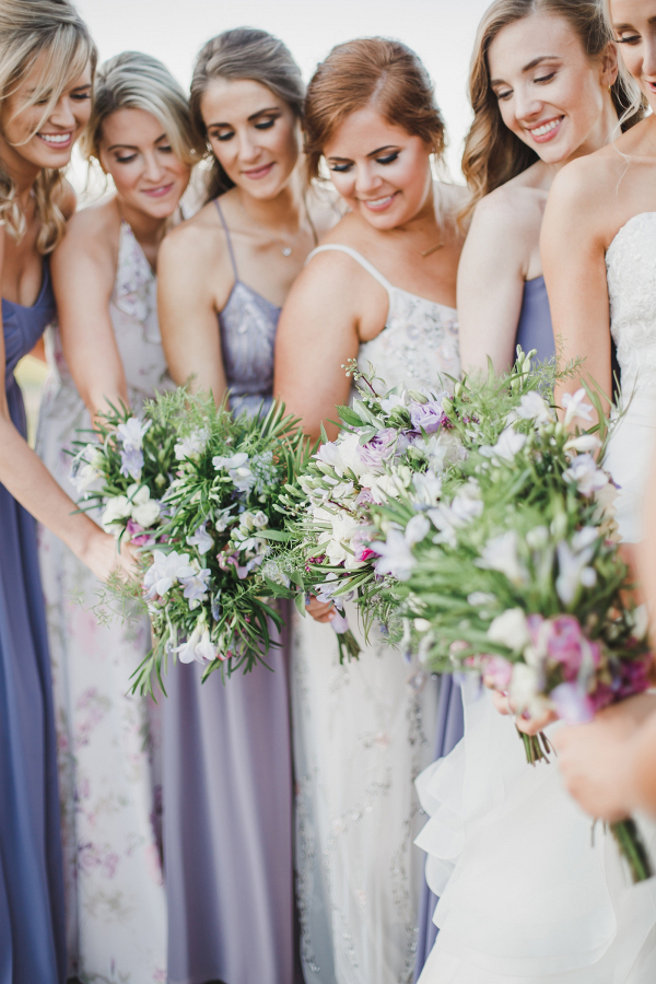 Bridesmaids in mismatched purple and lavender dresses