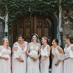 Bridal party in light blush gowns and feather fans