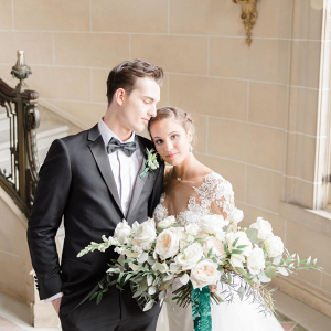 Elegant bride and groom in white, emerald green, and black