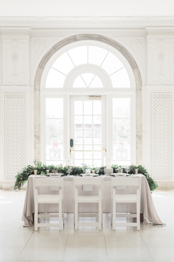 White and gray wedding table with long greenery runner