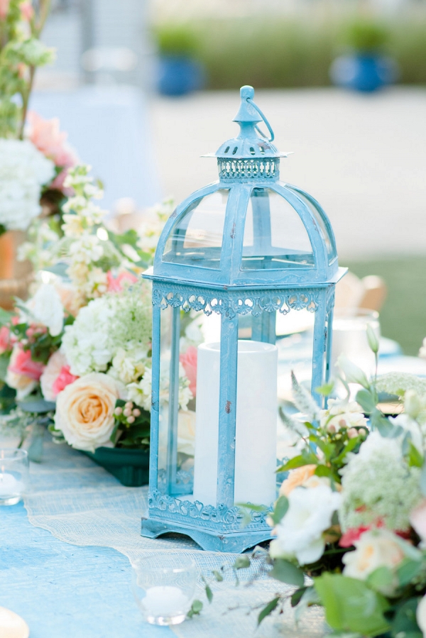 Outdoor, St. Petersburg Wedding Reception Table Decor with Wooden Chairs, Blue Table Linens, and Peach and Ivory Floral Wedding Centerpieces and Blue Lanterns