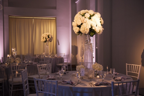 Wedding Reception Table Decor with Tall, Crystal Centerpieces with White Flowers and Crystals and White Chiavari Chairs | Pinspotting and Pink Uplighting 