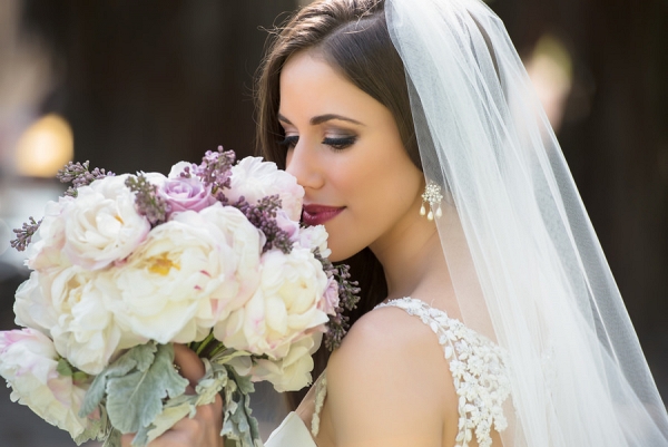 Outdoor, Bridal Wedding Portrait in Lace Wedding Dress and Veil and Purple and White Rose and Lilac Floral Wedding Bouquet of Flowers