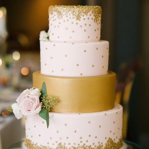 Four Tiered Round White and Gold Wedding Cake with Rose Floral Accent and Gold Sequins