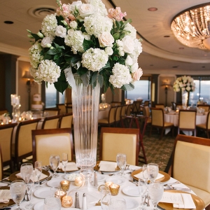 Elegant Indoor Tampa Wedding Venue with Tall Centerpieces with Hydrangeas and Roses and Chandeliers with Gold Charger Plates 