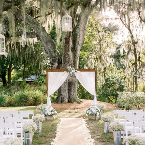 Rustic Outdoor Wedding with White Draped Altar and White Folding Chairs