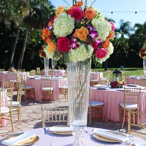 Outdoor Wedding Reception Décor with Gold Chiavari Chairs, Pink Linens and Orange, Bright Pink and Fuchsia Floral Centerpieces with Lanterns and Market Twinkle Lights 