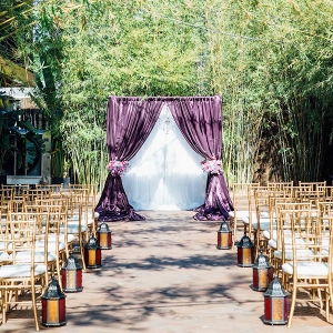 Outdoor Florida Wedding Ceremony with Purple Linen Flocked Archway and Gold Chaivari Chairs 