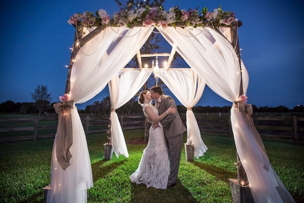 Nighttime, Twilight Bride and Groom Outdoor Wedding Portrait under Wedding Altar