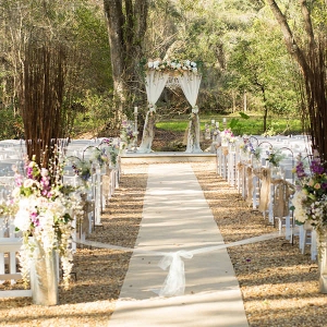 Outdoor, Rustic Wedding Ceremony Decor with Tall, Purple and Ivory Floral Aisle Decorations and Wooden Altar Decorated with Flowers