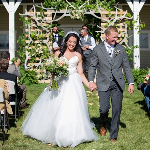 Rustic outdoor wedding ceremony with antler backdrop