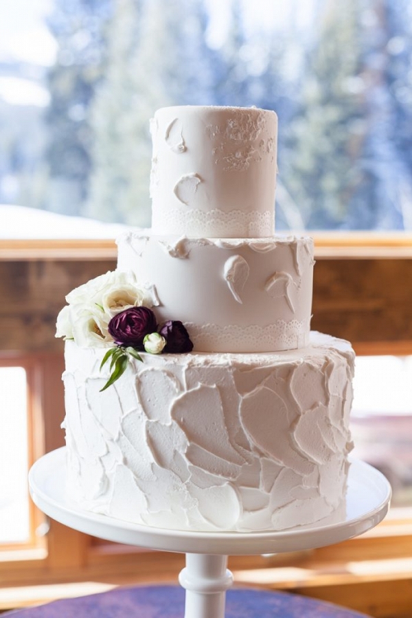 simple butter cream wedding cake with 3 tiers and burgundy and ivory ranunculus