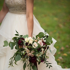 Ivory and burgundy bouquet with a gold and white wedding gown