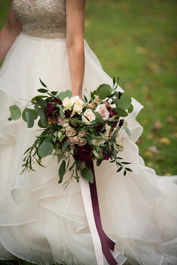 Ivory and burgundy bouquet with a gold and white wedding gown