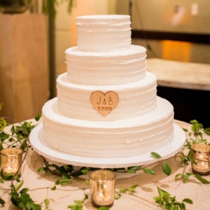 Simple, three-tier rustic wedding cake with wooden heart