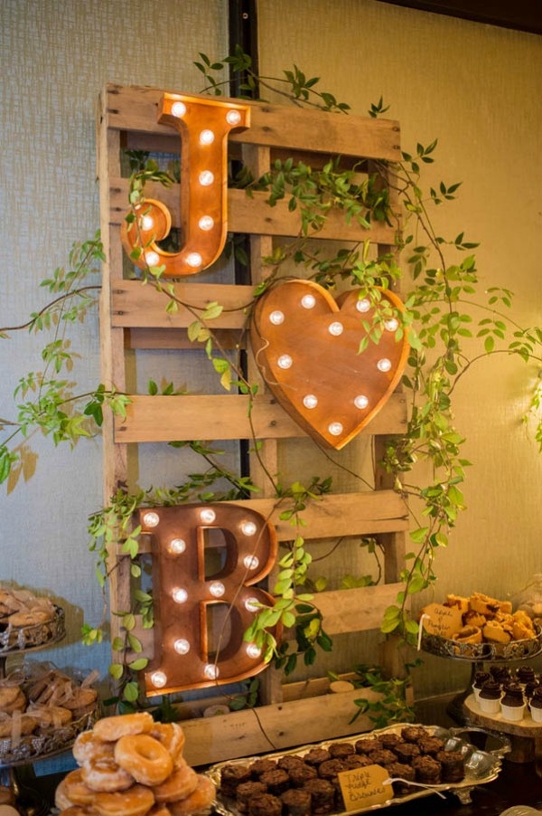 Marquee light monogram mounted on wooden pallet to create dessert bar sign