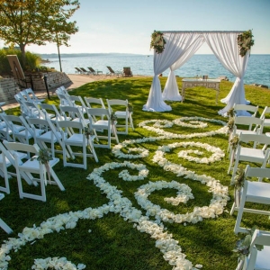 Romantic lakefront ceremony with flower petal designed aisle