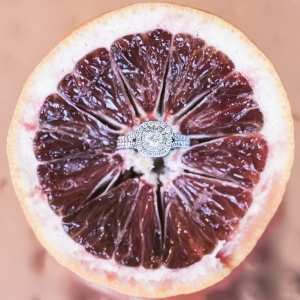 Halo engagement ring styled in a blood orange