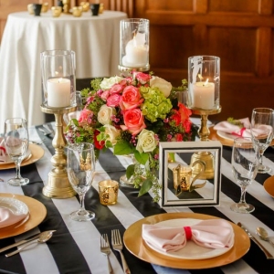 Black and white striped modern tablescape with gold and coral accents