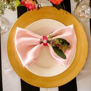 Black, white, gold and pink place setting with bow napkin