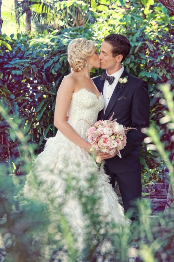 Bride and groom kissing in hotel garden