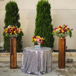 Modern rooftop ceremony with two wooden pillars and a table with a silver glitter tablecloth