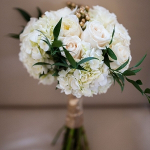 Elegant white wedding bouquet with gold highlights and greenery