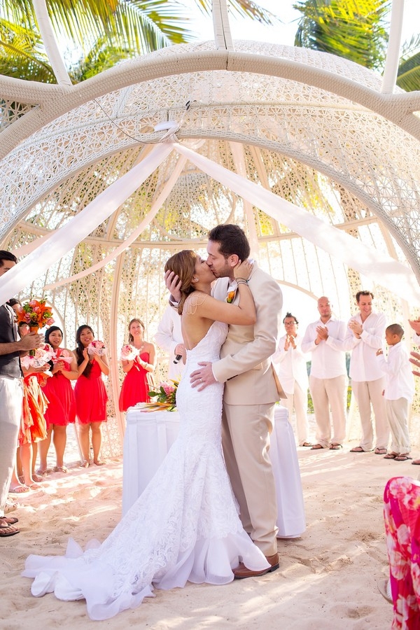 Modern destination wedding bride and groom sharing a kiss under the chic cabana at Sandos Caracol Eco Resort